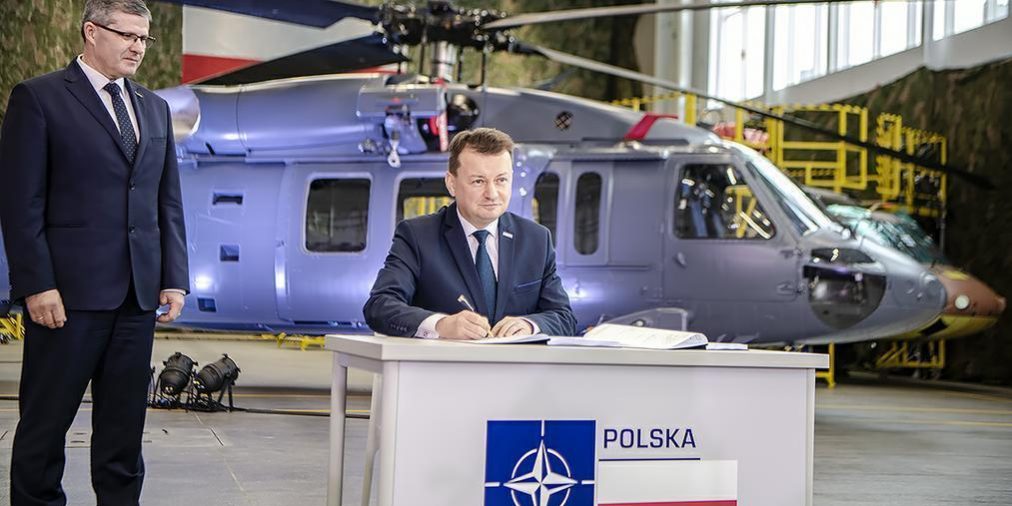 Minister Obrony Narodowej podpisuje kontrakt na zakup 4 S70i BlackHawk na tle policyjnego śmigłowca S70i