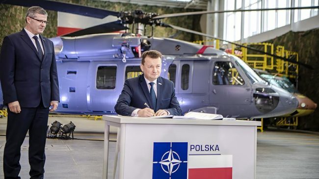 Minister Obrony Narodowej podpisuje kontrakt na zakup 4 S70i BlackHawk na tle policyjnego śmigłowca S70i