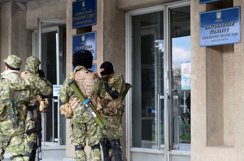 Prorosyjscy żołnierze pod Radą Miejską Słowiańska. Zamaskowani separatyści są uzbrojeni w karabiny szturmowe AK-74 oraz granatniki przeciwpancerne RPG-26. 14 kwietnia 2014 roku.