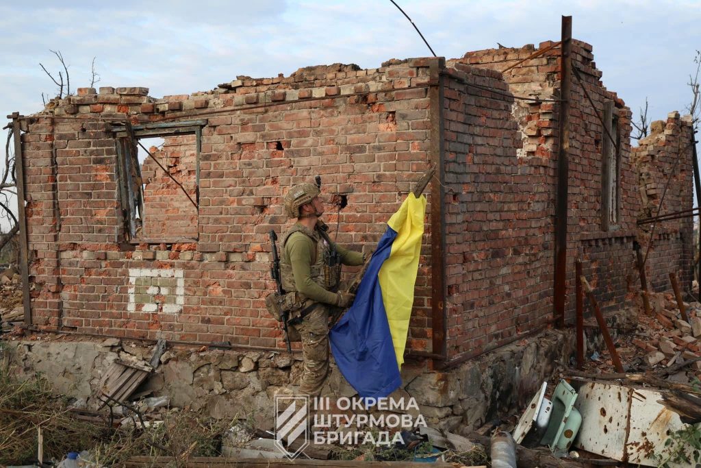 Żołnierz Ukrainy przygotowuje się do wywieszenia flagi w oswobodzonej miejscowości Andrijiwka w obwodzie donieckim.